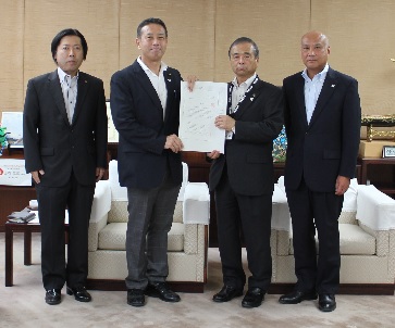 鶴ヶ島市公共施設個別利用実施計画（案）に関する報告書を手渡している写真