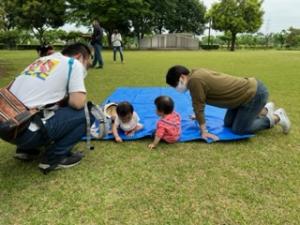 ブルーシートの上で交流する親子