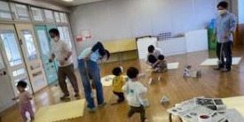 つくった新聞ボールで遊ぶ親子